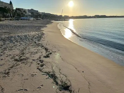 a beach with the sun rising over the water at Elegant studio a 50m de la Croisette et ses plages - Ada Serenity Beach in Cannes