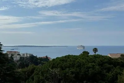 a view of the ocean with a ship in the water at Appartment with exceptional view on the sea in Cannes