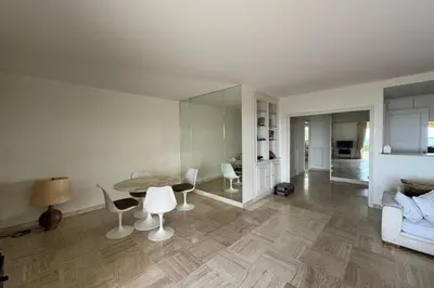 a living room with a table and chairs and a couch at Appartment with exceptional view on the sea in Cannes