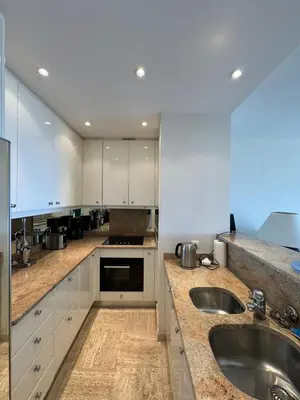 a kitchen with white cabinets and a sink at Appartment with exceptional view on the sea in Cannes
