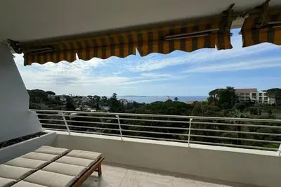 a balcony with a bench and a view of the ocean at Appartment with exceptional view on the sea in Cannes