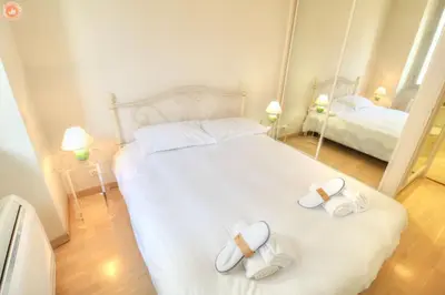 a bedroom with a large white bed with towels on it at ALC - FONT3 - 10 min PALAIS in Cannes