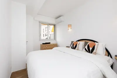 a white bedroom with a white bed and a window at Carlton area lux 2 beds 2 baths in Cannes