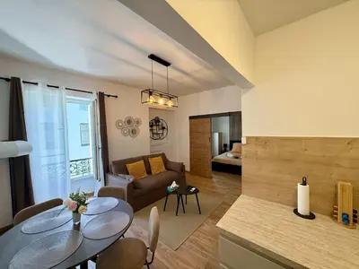 a living room with a table and a couch at A006 Superbe Appartement dans le Carre d'Or-Cannes in Cannes