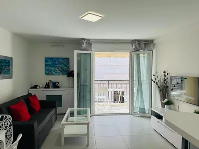 a living room with a couch and a large window at Modern Bright Cannes Apt 2 min walk to the Beach in Cannes