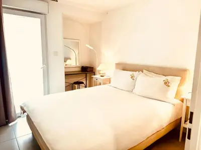 a white bed in a room with a window at Modern Bright Cannes Apt 2 min walk to the Beach in Cannes