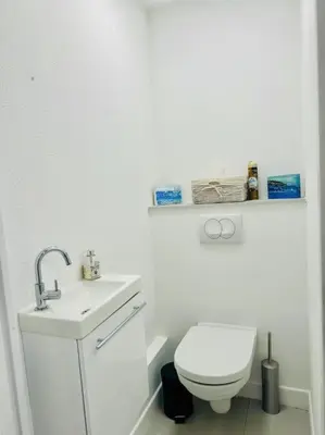 a white bathroom with a toilet and a sink at Modern Bright Cannes Apt 2 min walk to the Beach in Cannes