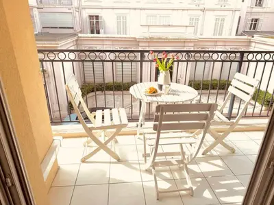 a balcony with a table and chairs on a balcony at Modern Bright Cannes Apt 2 min walk to the Beach in Cannes