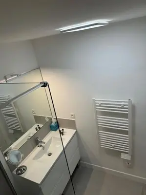 a white bathroom with a sink and a mirror at Modern Bright Cannes Apt 2 min walk to the Beach in Cannes