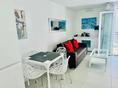 a living room with a couch and a table and chairs at Modern Bright Cannes Apt 2 min walk to the Beach in Cannes