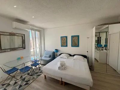 a bedroom with a bed and a glass table at Studio Cannes Carré d'Or in Cannes
