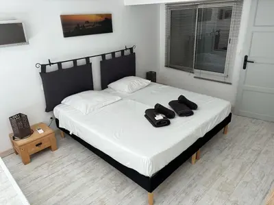 a bedroom with a bed with two pairs of shoes on it at Le Grenade - Spacieux 2 chambres Cannes centre 5min à pied in Cannes
