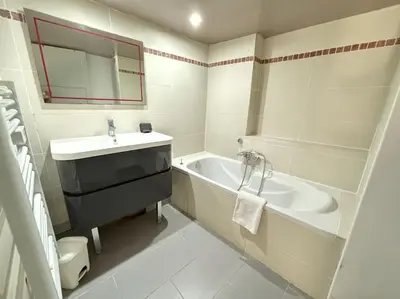 a white bathroom with a sink and a bath tub at Le Grenade - Spacieux 2 chambres Cannes centre 5min à pied in Cannes