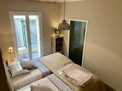 a bedroom with a bed and a window and a door at Maison CENTRE CANNES 2 CHAMBRES 4 COUCHAGES in Cannes
