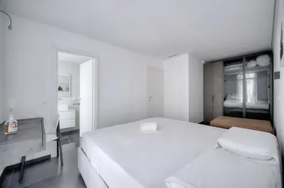 a white bedroom with a large white bed and a sink at Design 2 pièces CARRE D'OR -COEUR DE CANNES A1B205 in Cannes