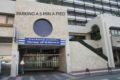 a building with a sign that reads parking a min a ped at Design 2 pièces CARRE D'OR -COEUR DE CANNES A1B205 in Cannes