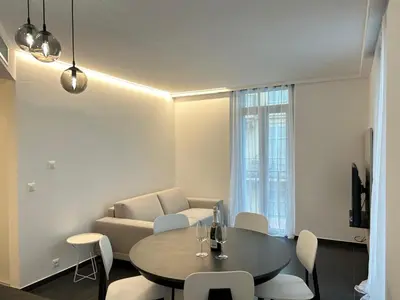 a living room with a table and a couch at Design 2 pièces CARRE D'OR -COEUR DE CANNES A1B205 in Cannes
