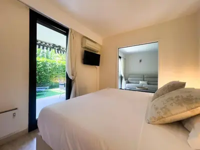 a bedroom with a large bed and a large window at Cocon paradisiaque avec piscine, terrasse, jardin au calme absolu in Cannes