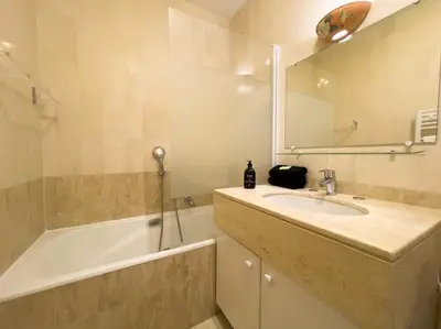 a bathroom with a sink and a tub and a mirror at Cocon paradisiaque avec piscine, terrasse, jardin au calme absolu in Cannes