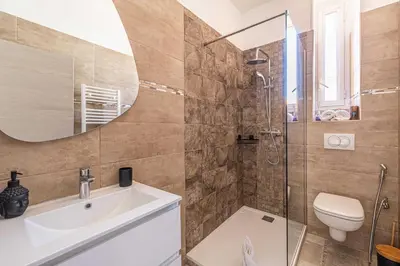 a bathroom with a sink and a toilet and a mirror at Cozy One Bedroom apartment - heart of Cannes in Cannes