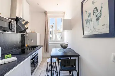 a kitchen with a counter and a small table in it at Cozy One Bedroom apartment - heart of Cannes in Cannes