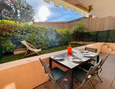 a patio with a table and chairs in a backyard at Appartement 2 pièces avec un jardin privatif in Cannes