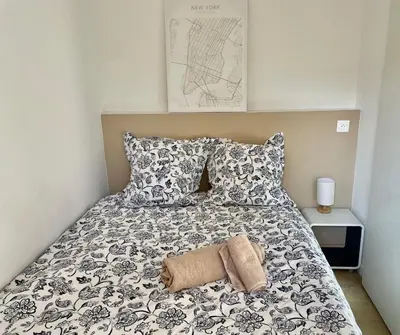a bed with a black and white blanket and pillows at Appartement 2 pièces avec un jardin privatif in Cannes