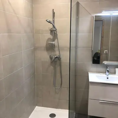 a shower with a glass door next to a sink at Appartement 2 pièces avec un jardin privatif in Cannes