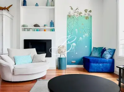 a living room with a white couch and a blue chair at Le Félix Faure - Palais Centre Cannes in Cannes