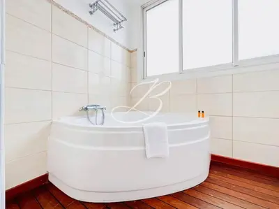 a white tub in a bathroom with a window at Le Félix Faure - Palais Centre Cannes in Cannes