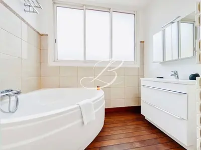 a white bathroom with a tub and a window at Le Félix Faure - Palais Centre Cannes in Cannes