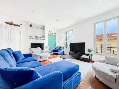 a living room with blue couches and a television at Le Félix Faure - Palais Centre Cannes in Cannes