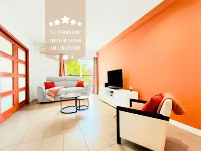a living room with a couch and a tv at Le TerrAzur - Logement 4 personnes Cannes in Cannes