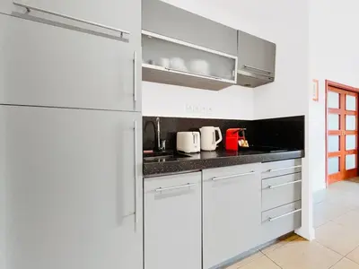 a white kitchen with white cabinets and appliances at Le TerrAzur - Logement 4 personnes Cannes in Cannes