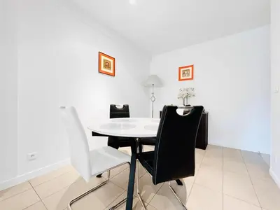 a white dining room with a white table and chairs at Le TerrAzur - Logement 4 personnes Cannes in Cannes