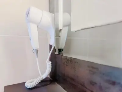 a white hair dryer hanging on a wall at Le TerrAzur - Logement 4 personnes Cannes in Cannes