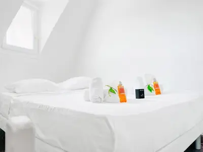 a white bed with towels and products on it at Le BlueAzur - Proche Palais centre Cannes in Cannes