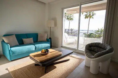 a living room with a couch and a chair and a table at Modern 1-bedroom apartment with sea view on La Croisette in Cannes