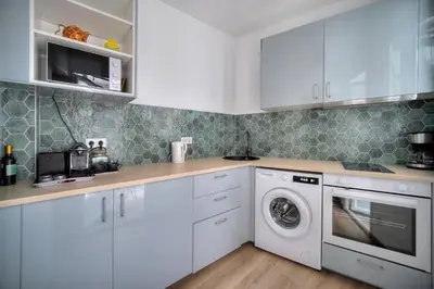 a kitchen with white cabinets and a washer and dryer at Elégant 2 pièces TERRASSE, SUQUET-CENTRE HISTORIQUE A1B261 in Cannes