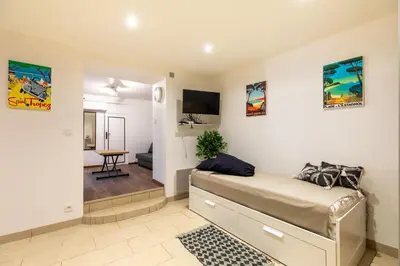a bedroom with a bed and a living room at La Succulente - T1 bis climatisé proche plage in Cannes