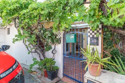 a house with a blue gate and some plants at La Succulente - T1 bis climatisé proche plage in Cannes