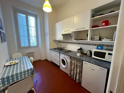 a kitchen with a table and a stove and a microwave at A004 - Bright apt Rue d'Antibes at 300m from beach Croisette in Cannes