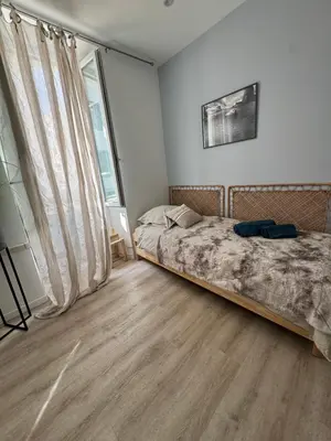 a bedroom with a bed and a large window at Cocon Bohème Cannes Croisette-Palais-Plages 200m in Cannes