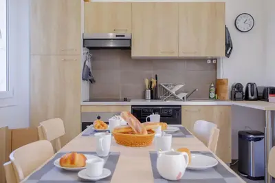 a kitchen with a table with food on it at Appartement familial, lumineux, calme avec parking in Cannes