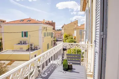 a balcony with a table and a view of a street at Appartement familial, lumineux, calme avec parking in Cannes