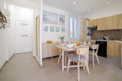 a kitchen and dining room with a table and chairs at Appartement familial, lumineux, calme avec parking in Cannes