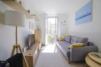 a living room with a couch and a tv at Appartement familial, lumineux, calme avec parking in Cannes