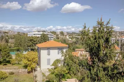 a small white house with an orange roof at Appartement familial, lumineux, calme avec parking in Cannes