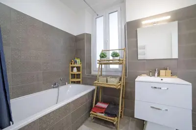 a bathroom with a bath tub and a sink at Appartement familial, lumineux, calme avec parking in Cannes