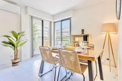 a dining room with a wooden table and chairs at Le Calmette - Logement Confort Centre Cannes in Cannes